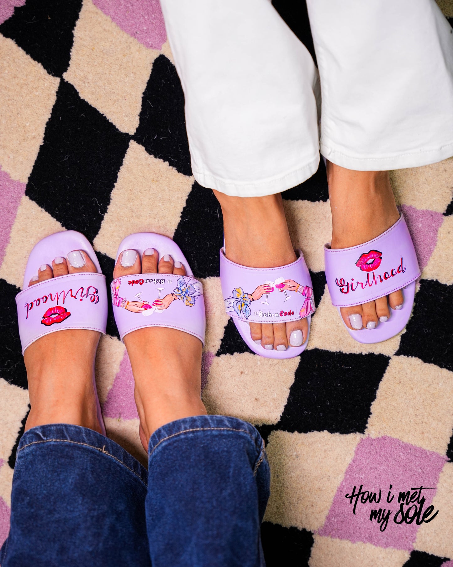Purple sandals with decorative designs worn on a checkered floor.