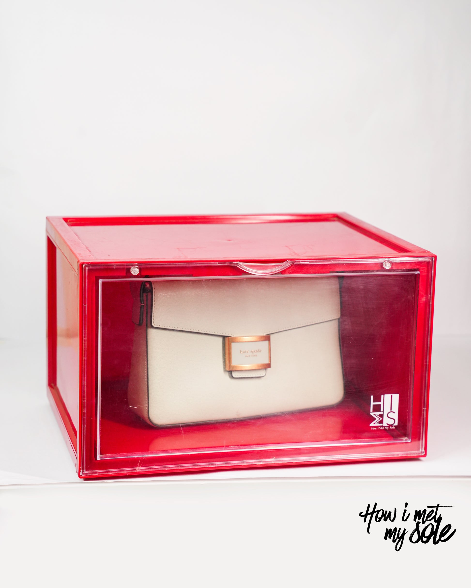 White luxury handbag inside a red style safe storage box with 'How i met my sole' branding